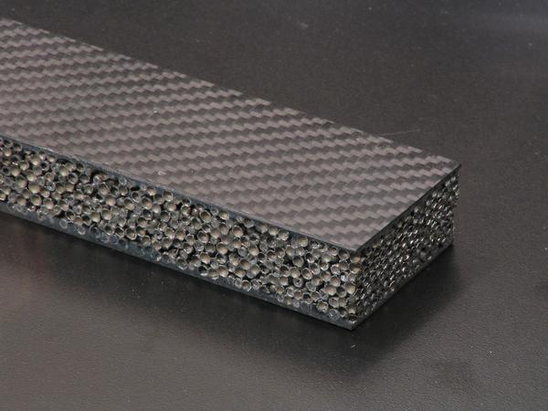 Carbon fibers with steel hollow balls
The surface from carbon fibers, in between a kind of metal foam. Many small hollow balls from steel form a frothy structure. High firmness with light weight.