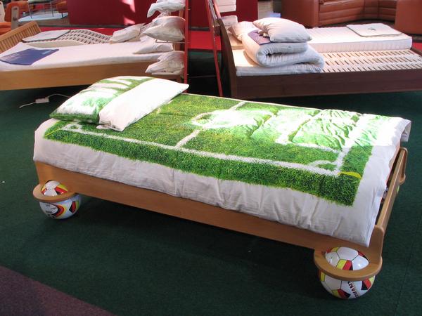 Fußball Weltmeisterschaft 2006 - das Bett für Fans
Das Bett schwebt auf 4 Fußbällen, die Bettdecke zeigt ein Fußballfeld, die inneren Werte von diesem Bett für Fußballfans sind ein spezieller Schaumstoff für erholsamen Schlaf.