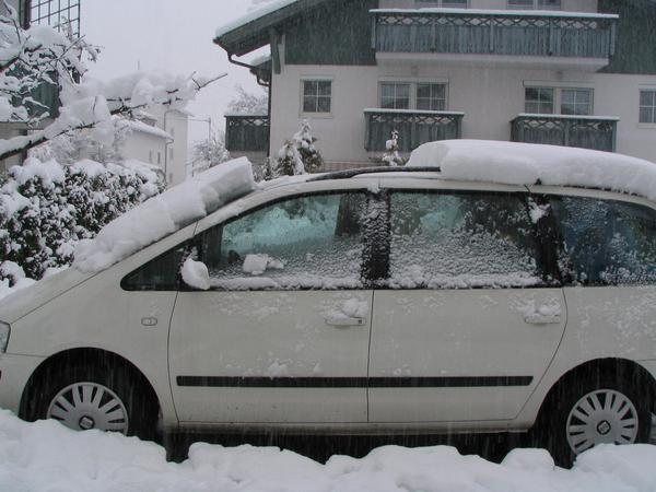 Water film lets slide the snow
80 minutes after I was car driving, all the snow from the front of the roof had slid to the windshield. The warmth from the interior room has melted a thin layer of snow..